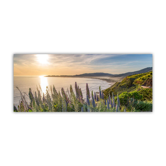 A panoramic view of a coastal landscape at sunset, with a lush green hillside and a body of water in the foreground. The sky is filled with warm, golden hues, creating a serene and picturesque scene. Stinson Beach Sunset Panorama Print - Marin County California Art