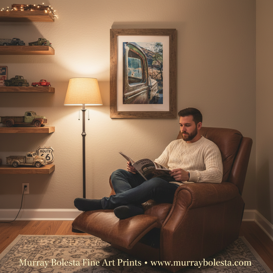 A man relaxes in a brown leather recliner reading a book in a warmly lit living room, with a framed art print of an old truck cab hanging on the wall above him. The room includes wooden floating shelves with toy cars and a floor lamp. by Murray Bolesta