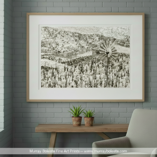 A windmill stands in a snowy landscape, its blades spinning in the breeze. Arizona Desert Cactus & Windmill Art Print - Ranch Landscape Photo by Murray Bolesta