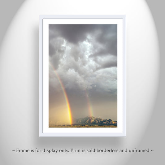 a stunning natural landscape with a vibrant rainbow arching across the sky, set against a backdrop of dramatic clouds and a distant mountain range.