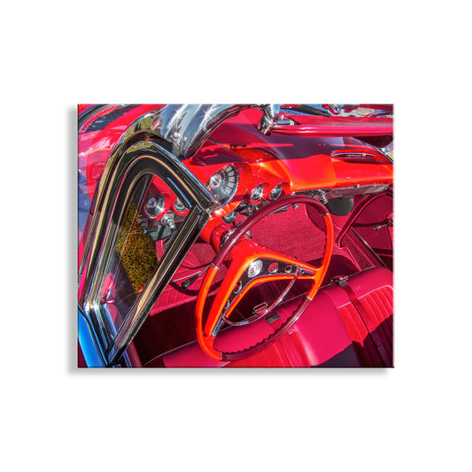 The image is a close-up of a vibrant red car's interior, showcasing the steering wheel, dashboard, and other features in a striking color scheme. Impala Car Art Print – Mancave Wall Decor Classic Car Photo