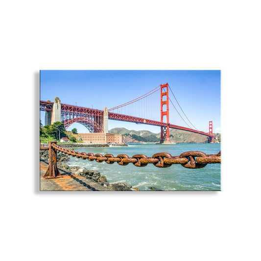 the iconic Golden Gate Bridge spanning the San Francisco Bay, with its distinctive red towers and suspension cables. The bridge is shown from a distance, providing a panoramic view of this famous landmark.Fort Point San Francisco with Golden Gate Bridge | Presidio Art
