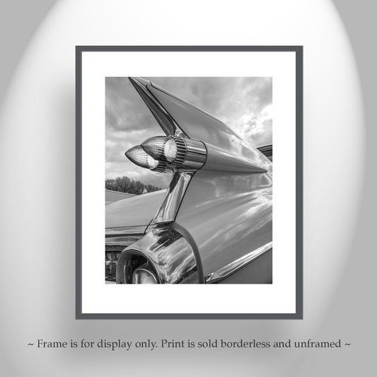 The image is a black and white photograph of a chrome car's tail fins, Cadillac Tail Fins Picture – Black & White Classic Car Art