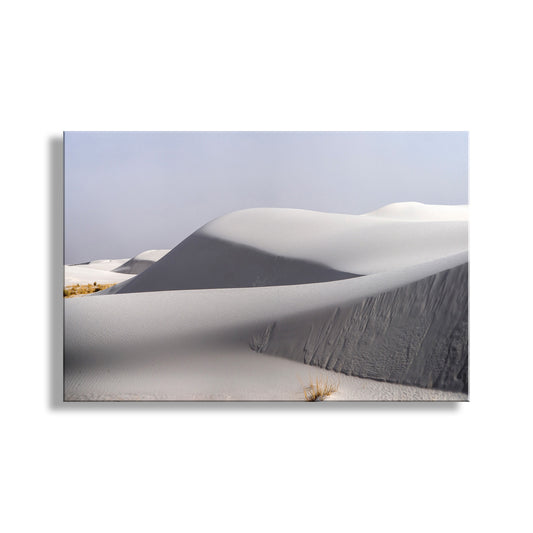 A vast expanse of snow-covered dunes stretches out under a clear blue sky, with a few small shrubs visible in the foreground. White Sand Dunes National Park Art - New Mexico Landscape Photography