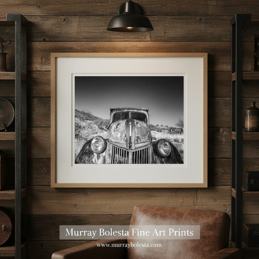 An old, rusted car sits abandoned in a field, its once-functional parts now rusted and weathered. Old Farm Truck Art Black and White Photography by Murray Bolesta