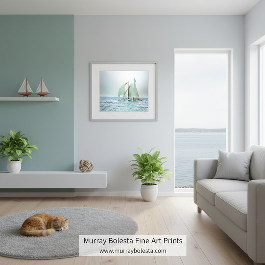 A framed art print of a sailboat on blue water hangs on a light gray wall in a modern living room with a sofa, plants, and a cat on a rug. The print is the product being showcased, and the watermark at the bottom reads 'Murray Bolesta Fine Art Prints'.