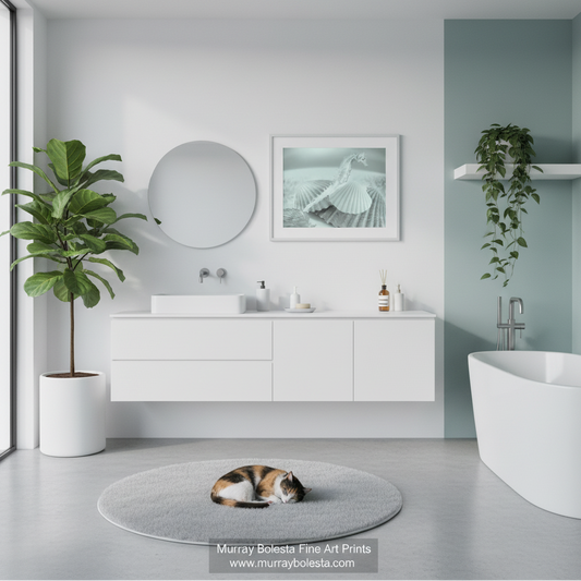 Seashell art! A modern bathroom interior with a white floating vanity, round mirror, framed art, potted plants, a freestanding tub, and a cat sleeping on a round rug. A watermark at the bottom reads Murray Bolesta Fine Art Prints.