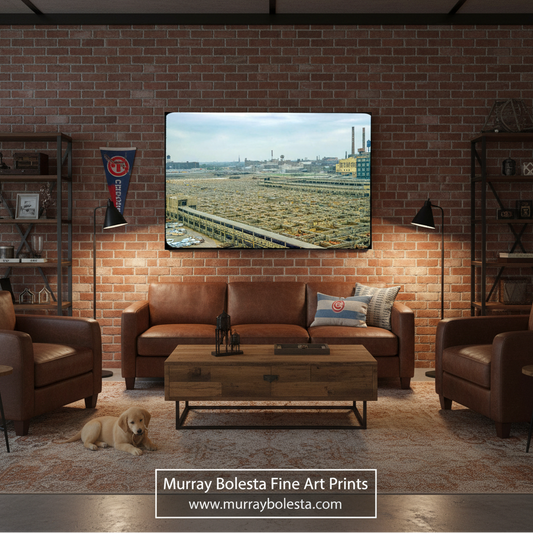 A framed art print depicting an industrial landscape is displayed on a brick wall above a brown leather sofa in a styled living room mockup. A watermark at the bottom reads 'Murray Bolesta Fine Art Prints'.