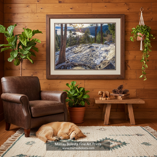 a serene natural landscape with a rocky shore, a waterfall cascading down, and a forested area in the background. Sierra Mountain Tahoe Waterfall Art | Emerald Bay Sunrise Picture by Murray Bolesta