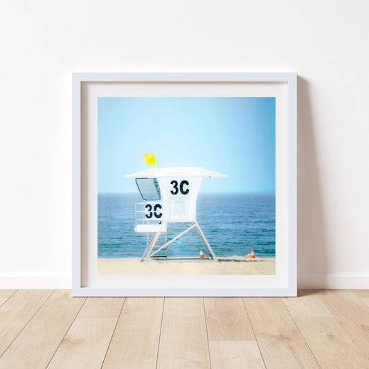 Framed artwork of a lifeguard stand on a beach with a blue sky. Lifeguard Tower Picture on San Diego California Beach | Square Picture