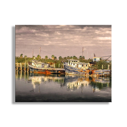 a serene harbor scene with two boats docked in the calm water, surrounded by lush greenery and a cloudy sky. South Padre Island Shrimp Boat Art – Vintage Nautical Print Texas