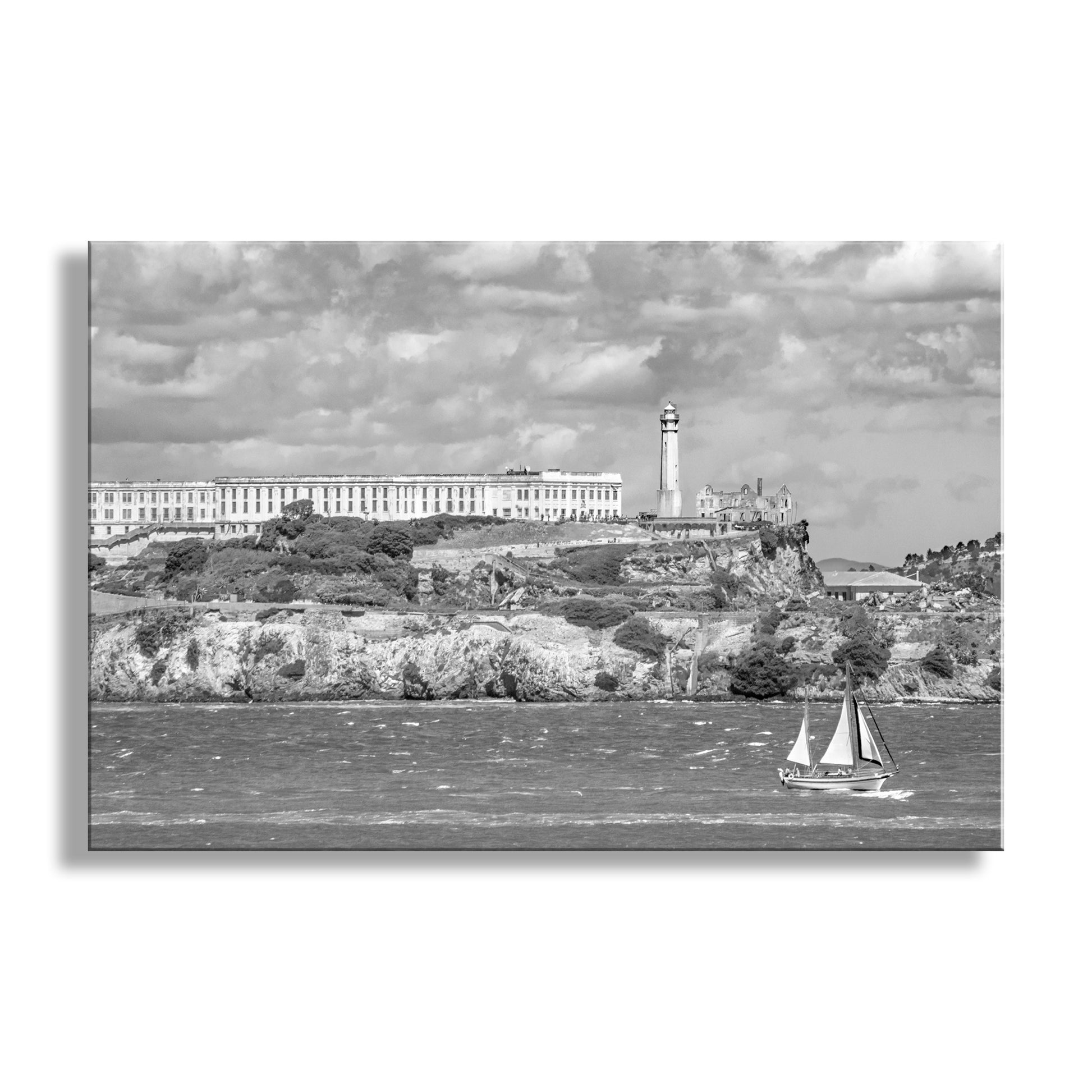 Black and white image of a coastal scene with a lighthouse and sailboat.  My awesome Alcatraz picture at California's San Francisco Bay, captured by me on a crisp Bay Area morning! Original, unique signed art by Murray Bolesta.