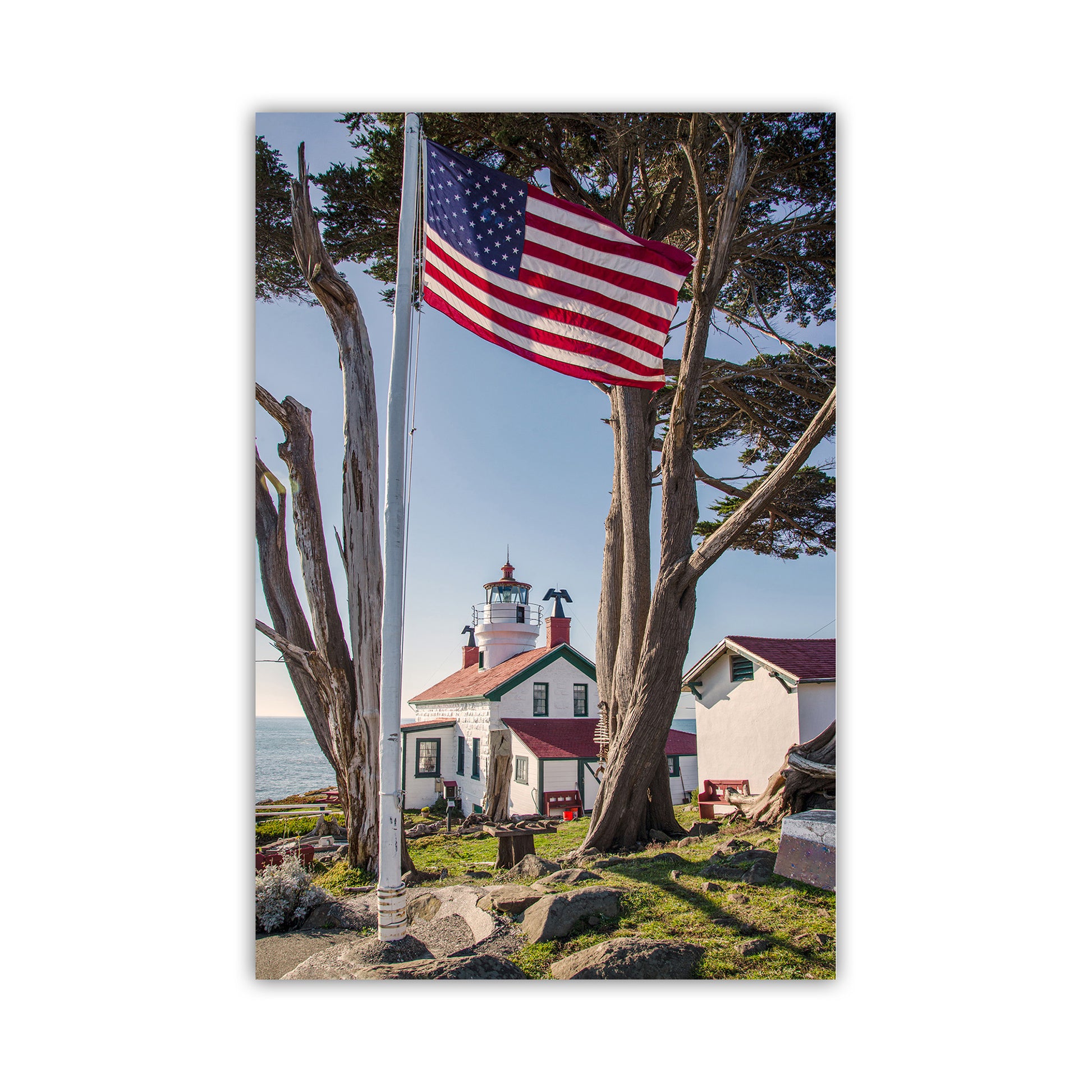 Lighthouse with American flag and trees in the foreground. Beautiful lighthouse art! For your walls, my cool lighthouse print from Crescent City, California. In the heart of Northern California's redwood coast, this is Del Norte County and the North Coast. This was one of the earliest lighthouses constructed on the USA West Coast, soon after California became a state. Original, unique signed art photograph by Murray Bolesta.