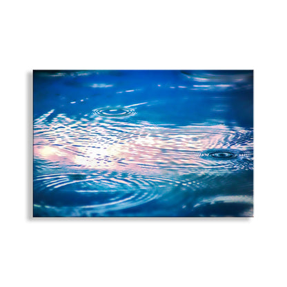 Ripples on water surface with colorful reflection. Fine Art Nature Photography with Raindrops in Indigo Blue
