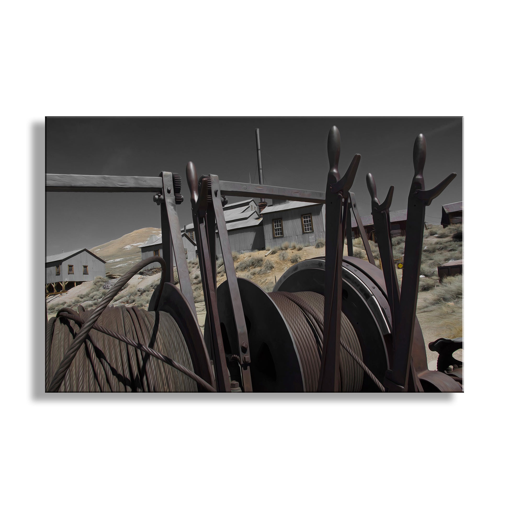 Vintage metal reels with a desert landscape and buildings in the background. My unique artwork of the time-worn ghost mining camp of Bodie! This place is a precious relic of western USA heritage in the high California desert, lovingly protected by vigilant state park staff. Original, unique signed art by Murray Bolesta.