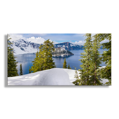 Scenic view of a lake surrounded by snow-covered mountains and trees. My pretty panorama of Crater Lake, Oregon, in all its wintertime splendor, to beautify your walls! This alpine lake is the result a colossal explosion in which Mount Mazama lost its head in a fit of pique. Since it happened only 7 or 8 thousand years ago, Native Americans actually witnessed the cataclysm which eventually provided a deep repository for a whole lot of very pure water. Original, unique signed art by Murray Bolesta.