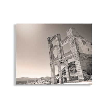 A black and white photograph of a dilapidated building with crumbling walls and columns, set against a mountainous landscape. Rhyolite Ghost Town Art - Death Valley Nevada Desert Photography