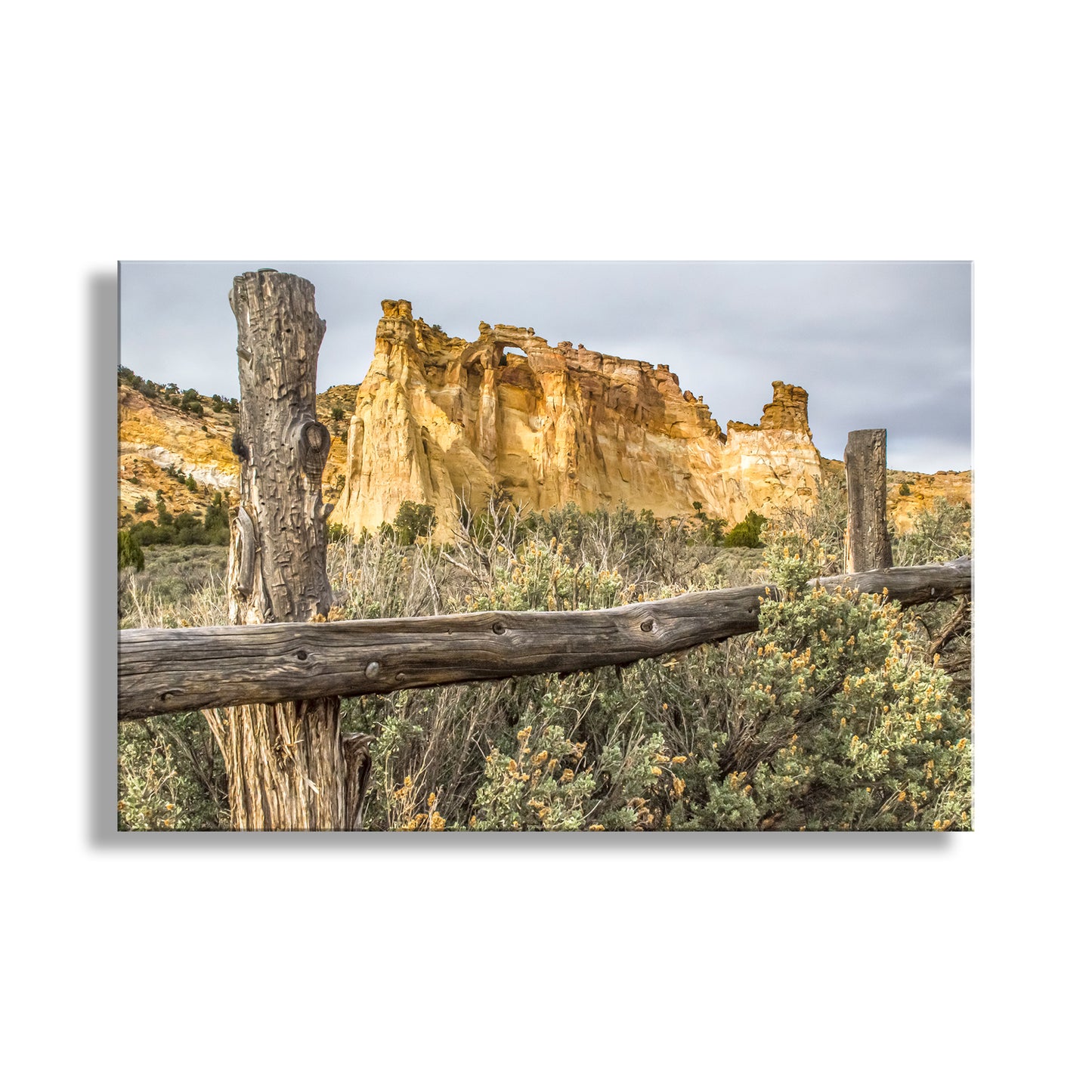 Scenic landscape with a wooden fence, rocky cliffs, and desert vegetation. Grosvenor Arch Southern Utah Landscape Art Print as Desert Wall Decor
