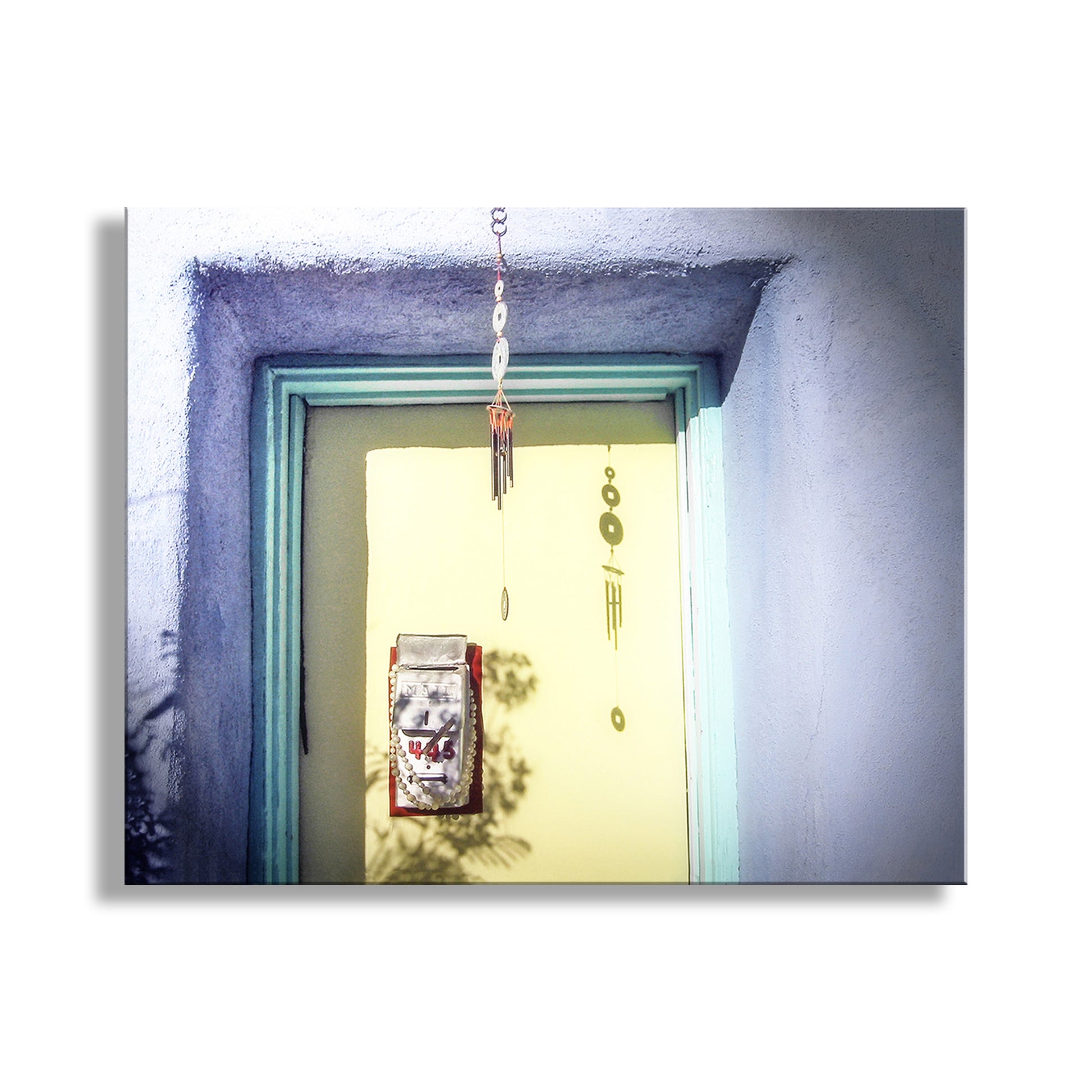 Decorative item hanging above a door with a light blue frame. Tucson Arizona Barrio Door Photograph with Vintage Adobe House