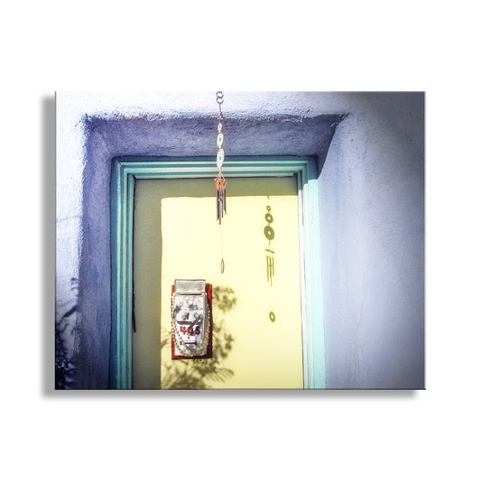 Decorative item hanging above a door with a light blue frame. Tucson Arizona Barrio Door Photograph with Vintage Adobe House