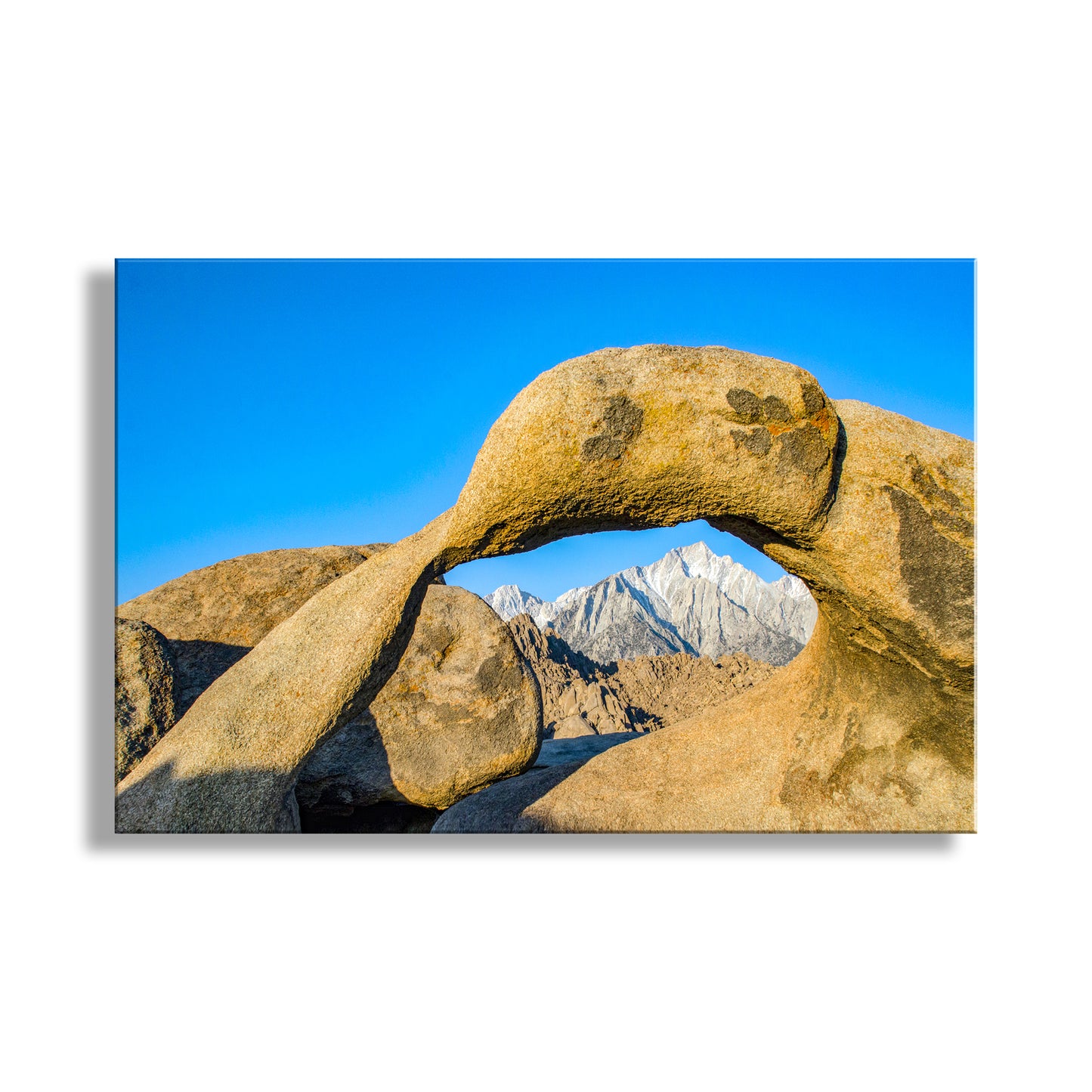 Rocks forming an arch with mountains in the background under a clear blue sky. Mobius Arch Art Print | Mount Whitney Photograph in California Desert