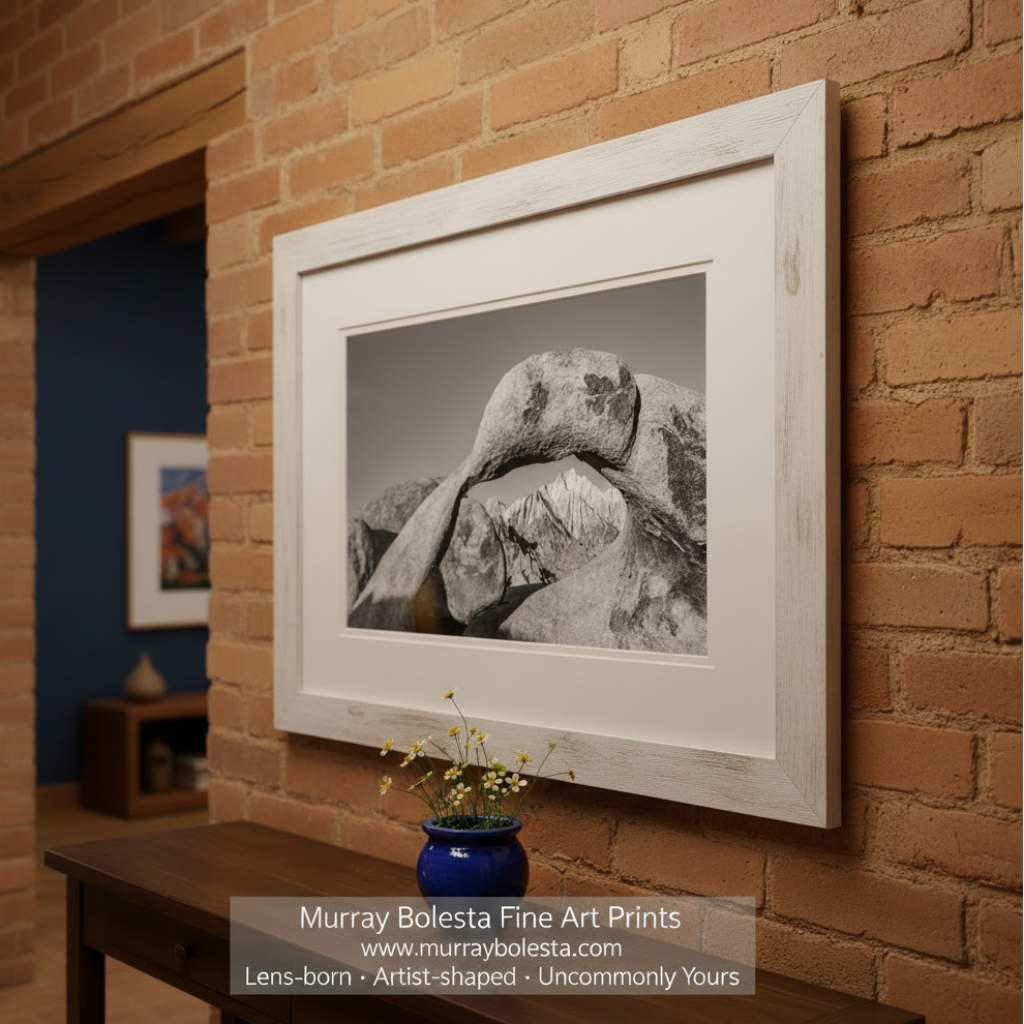 Black and white photo of a natural stone archway with mountains in the background. Alabama Hills Photograph as California Desert Western Landscape Wall Art in Black and White by Murray Bolesta