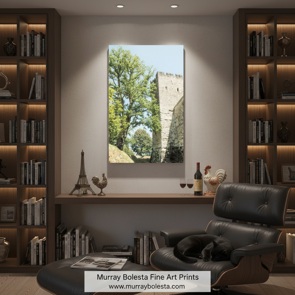 a stone castle tower surrounded by lush green trees, with a clear blue sky in the background. French Castle Art Print in Aquitaine France | Wall Decor Francophile by Murray Bolesta