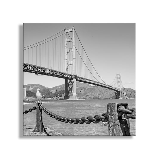 Black and white image of a suspension bridge with a seagull on a chain. Beautiful Fort Point! My square Golden Gate Bridge photograph for your walls. In this scene, San Francisco's unique Fort Point attracts a seagull as well as me! Original, unique signed art by Murray Boles