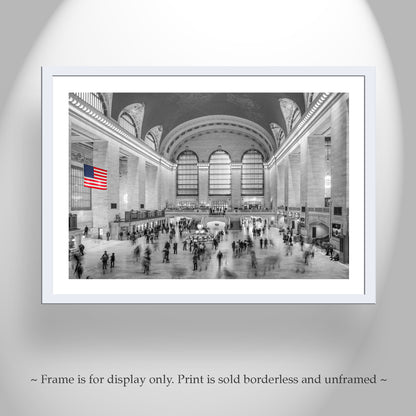 Framed print of a busy train station with an American flag, displayed on a gray wall. Grand Central Terminal New York City Black & White Wall Art Decor