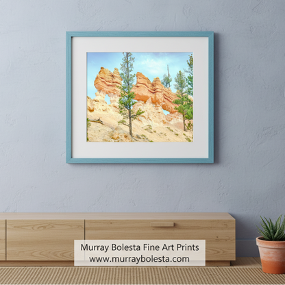a rocky landscape with tall, orange-colored rock formations, including a large rock formation with a hole in the middle. The scene is surrounded by trees and shrubs, creating a natural and picturesque setting. Bryce Canyon Utah Desert Hoodoo Landscape Art Print by Murray Bolesta