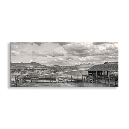 Black and white landscape with a wooden fence and shed under a cloudy sky. Western Landscape Panoramic Art | Empire Ranch Sonoita Arizona