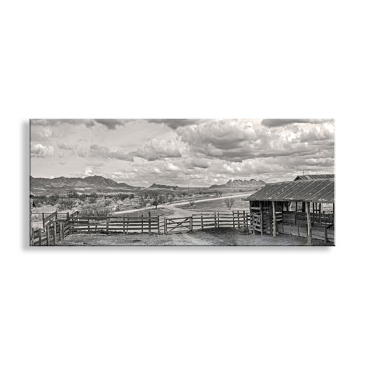 Black and white landscape with a wooden fence and shed under a cloudy sky. Western Landscape Panoramic Art | Empire Ranch Sonoita Arizona