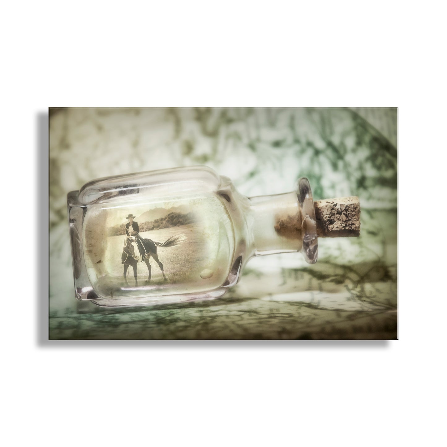 Glass bottle with cork stopper containing a photo of a person and horse on a textured background. Fine Art Print with Horsewoman | Equestrian Artwork with Spanish Barb Horse