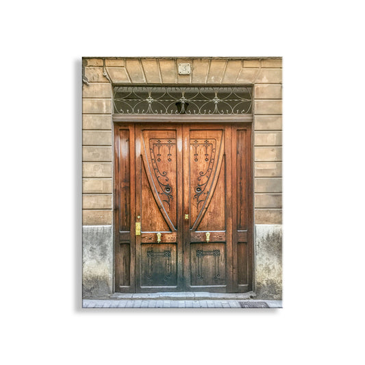 Wooden door with decorative ironwork above it on a stone building facade. Palma Majorca Spain Architecture Art as Travel Home Decor