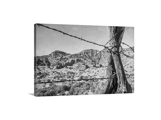 Barbed wire fence with desert landscape in the background. Western Landscape Photography in Black and White with Arizona Desert Ranch Country and Barbed Wire Fence
