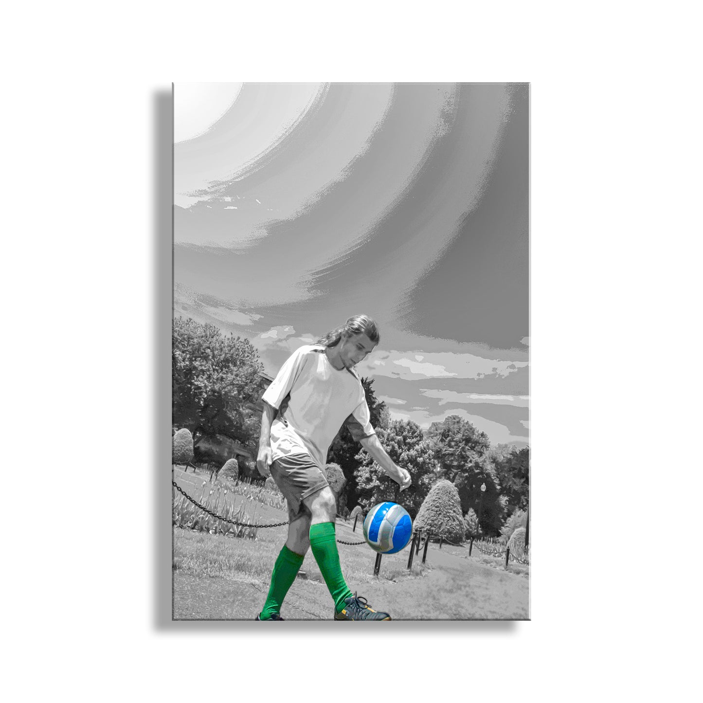 Person playing soccer with a blue and white ball on a grassy field, with a scenic background. My shot of an athlete practicing his juggling soccer drills. I captured this image in Boston Massachussetts! Original, unique signed art by Murray Bolesta.