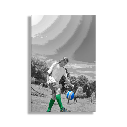 Person playing soccer with a blue and white ball on a grassy field, with a scenic background. My shot of an athlete practicing his juggling soccer drills. I captured this image in Boston Massachussetts! Original, unique signed art by Murray Bolesta.