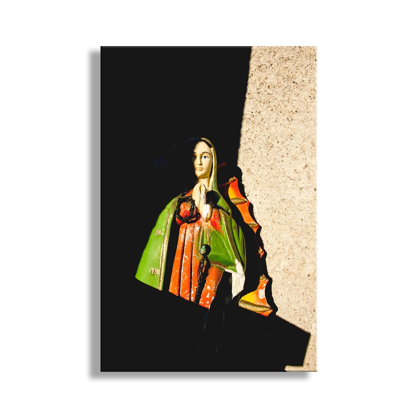 Statue of a person in historical attire against a black background. Tucson Arizona Framed Art with Virgin of Guadalupe at Barrio Viejo Old Pueblo