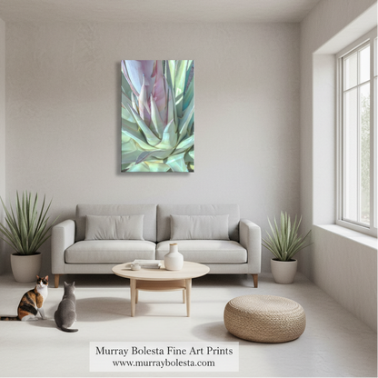 Agave pastel by Murray Bolesta! A framed abstract botanical art print hangs on a light beige wall above a modern light gray sofa in a bright, minimalist living room. The artwork features soft blended tones of green, teal, lavender, and pink.
