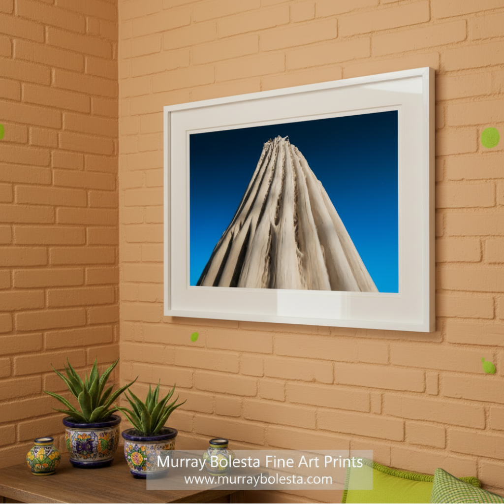 A tall, jagged, and weathered tree trunk against a clear blue sky. Abstract Cactus Photography | Indigo Desert Botanical Wall Art by Murray Bolesta