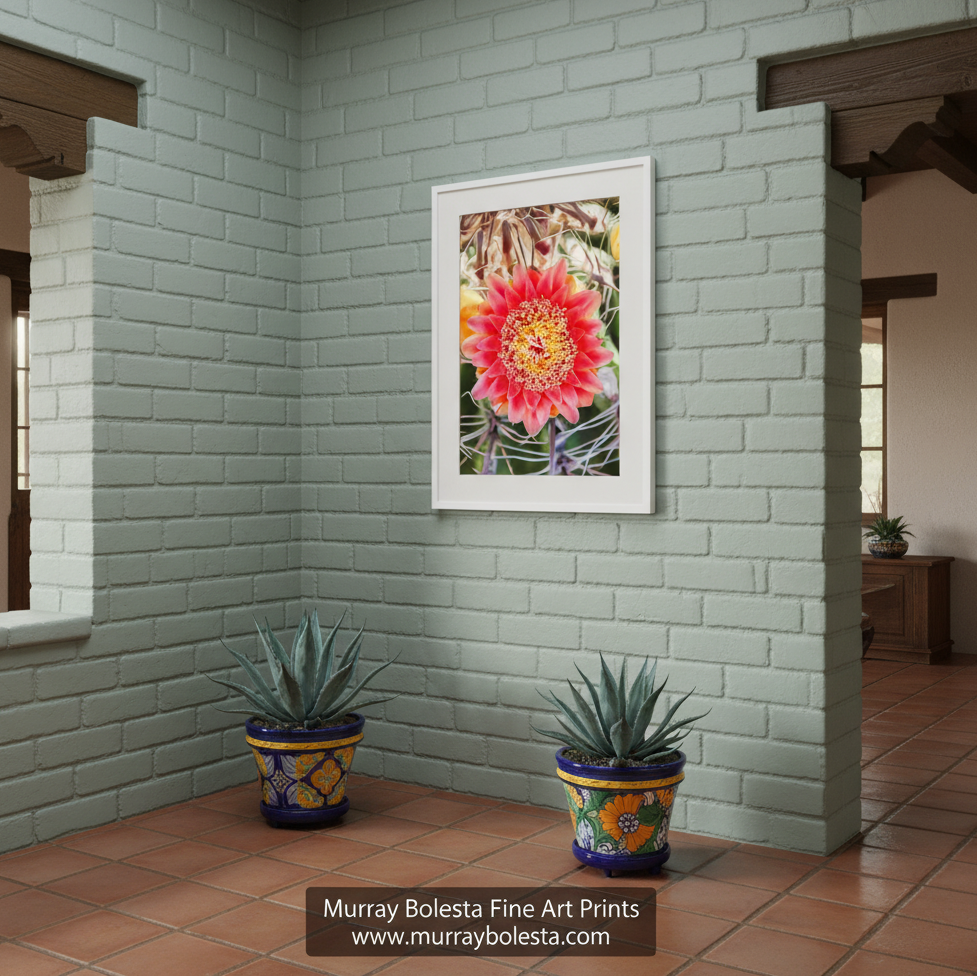 A vibrant red flower with yellow centers is the focal point of the image, surrounded by a blurred background of green leaves and stems. Barrel Cactus & Wildflower | Arizona Desert Botanical Art Print by Murray Bolesta