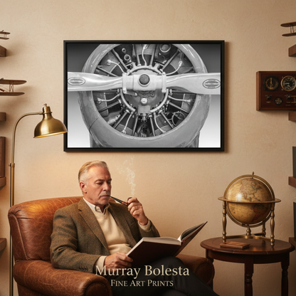A framed black-and-white art print of an airplane propeller hangs on a beige wall in a vintage study. A man sits in a brown leather armchair below, reading a book and smoking a pipe, with shelves of books, model airplanes, and a globe around him.