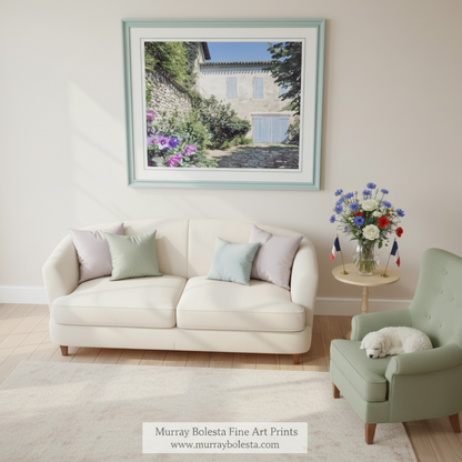a charming stone building with blue shutters, surrounded by lush greenery and vibrant purple flowers. Quaint France Stone Cottage Print | French Village Wall Art by Murray Bolesta!