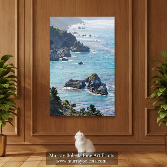 Big Sur Coast California! A vertical canvas print of a coastal landscape with turquoise ocean water, rocky cliffs, and white surf, displayed on a wooden wall above a wooden floor with a white cat sitting in front. The text 'Murray Bolesta Fine Art Prints' is visible at the bottom.