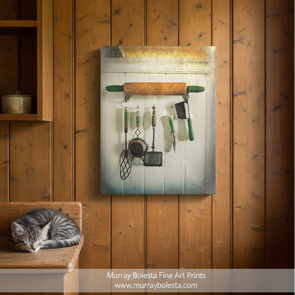 A collection of vintage kitchen utensils, including a rolling pin, a whisk, and a spatula, hanging on a wooden wall. Block Island Vintage Kitchen Art Print | Old Utensils Wall Decor by Murray Bolesta