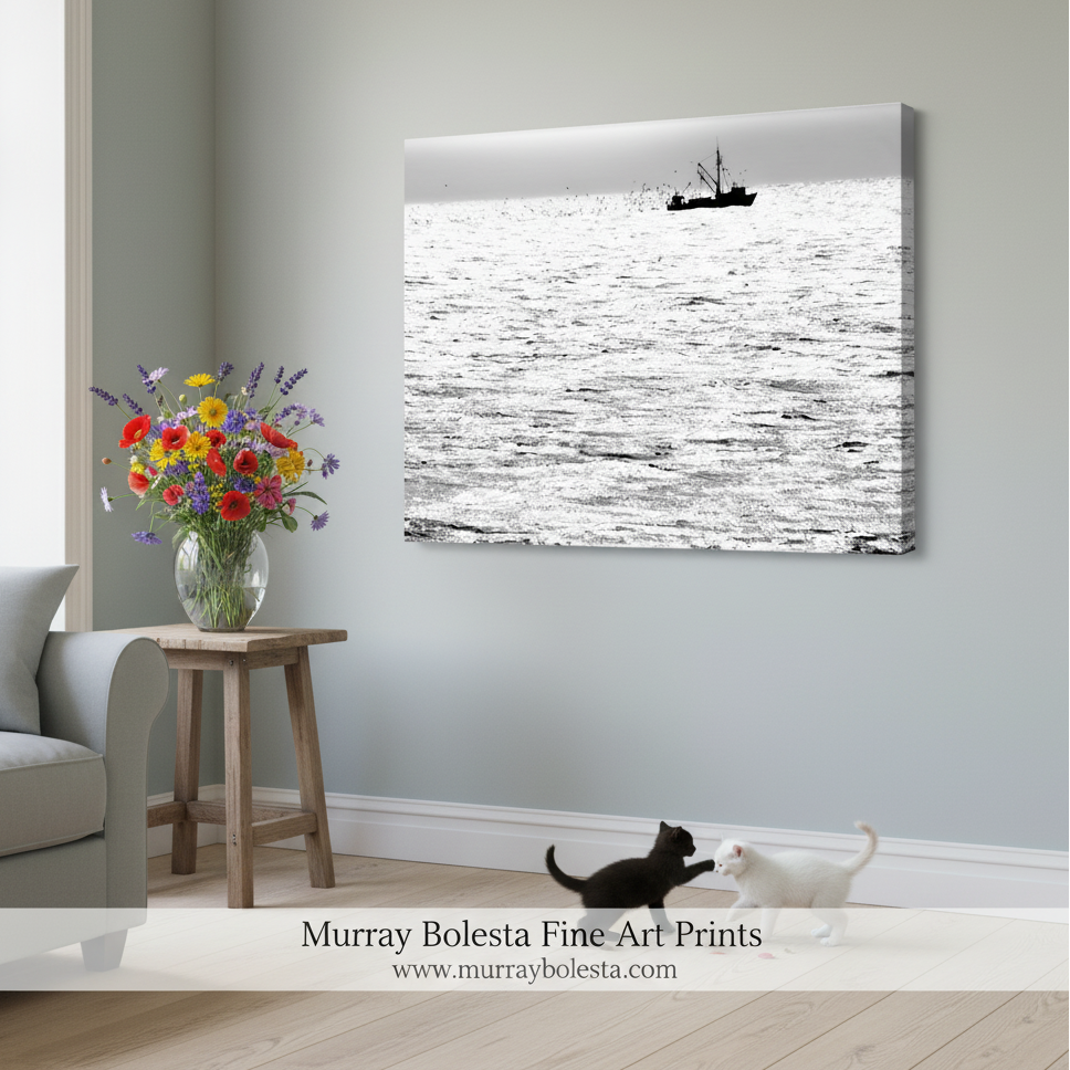 A black and white image of a fishing boat sailing on a calm body of water, with a flock of birds flying in the background. Block Island Fishing Trawler Art Print | Black & White Ocean Photo by Murray Bolesta
