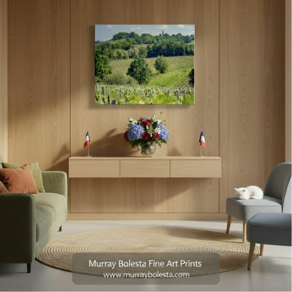 A picturesque countryside landscape with vineyards, rolling hills, and a church spire in the distance. French Vineyard Photography Bordeaux | Wine Country Landscape Art by Murray Bolesta