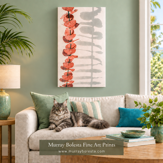 A vertical canvas art print featuring a stylized red-orange eucalyptus stem on a white background with soft gray leaf shadows, displayed on a sage green wall above a beige sofa with a cat resting on it. The text overlay at the bottom reads 'Murray Boleta Fine Art Prints'.