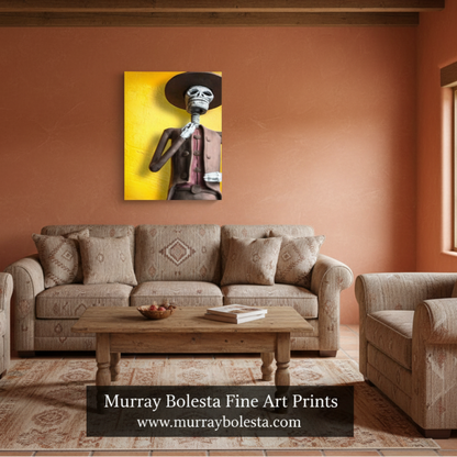 A framed wall art print showing a stylized skeleton figure against a bright yellow background, displayed above a beige sofa in a rustic living room with terracotta walls and wood ceiling beams. Text at the bottom reads 'Murray Bolesta Fine Art Prints' with a website. Day of the Dead.
