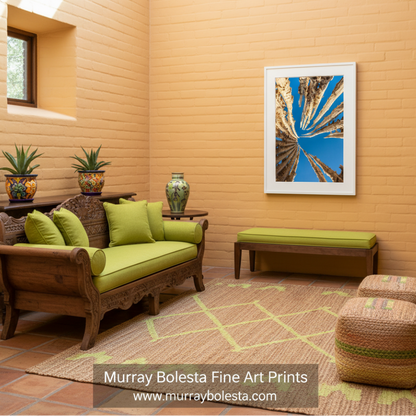 a striking view of a clear blue sky, with a series of tall, thin, and twisted tree trunks or branches extending upwards and outwards, creating a sense of depth and perspective. Abstract Cactus Spines | Indigo Desert Botanical Wall Art Print by Murray Bolesta